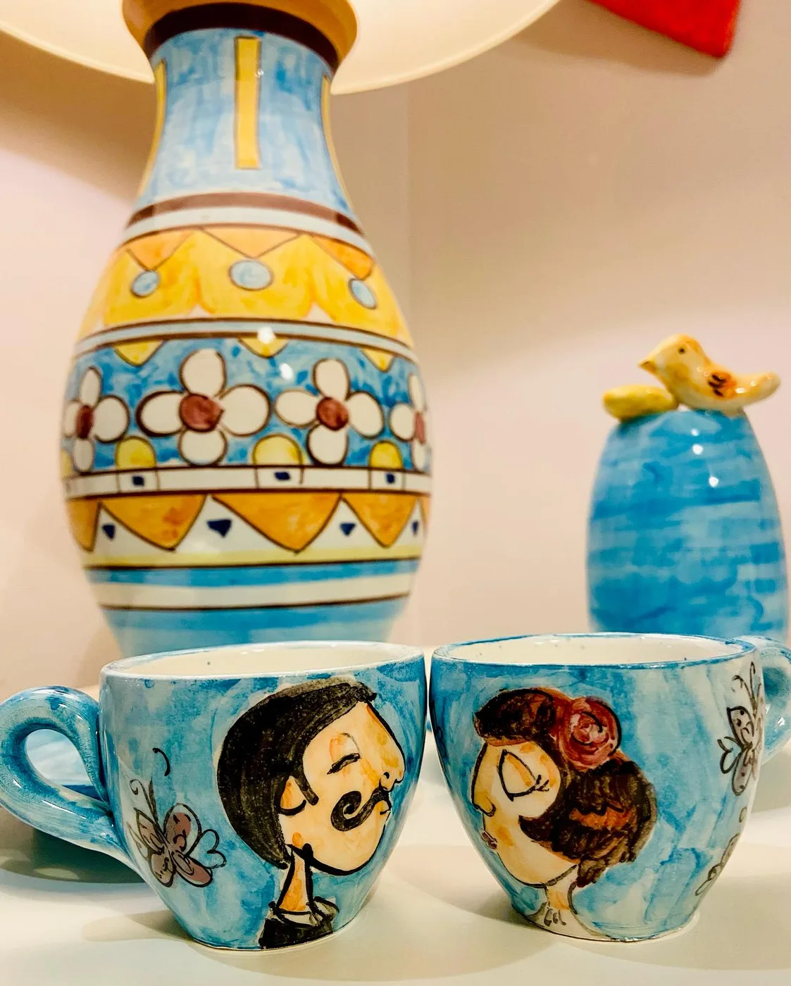 Vaso dipinto in blu e giallo con le tazze coi volti